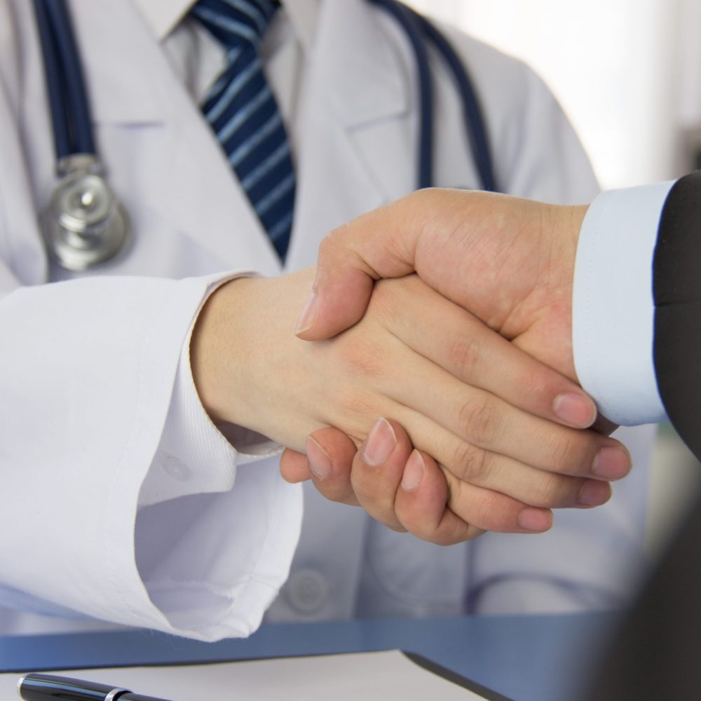 Doctor and businessman shaking hands
